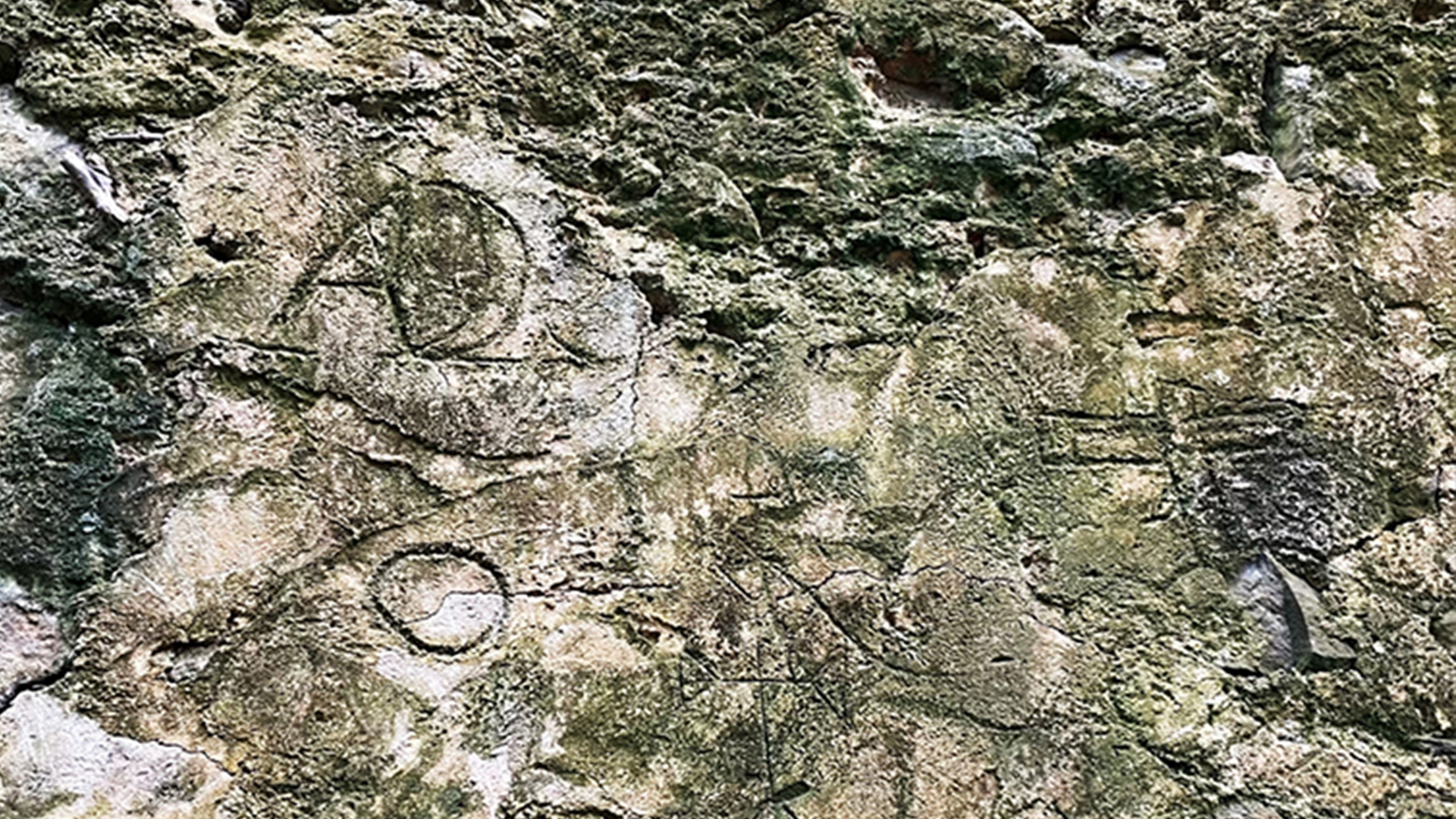 Dinding batu tua menampilkan grafiti dari era perdagangan budak.