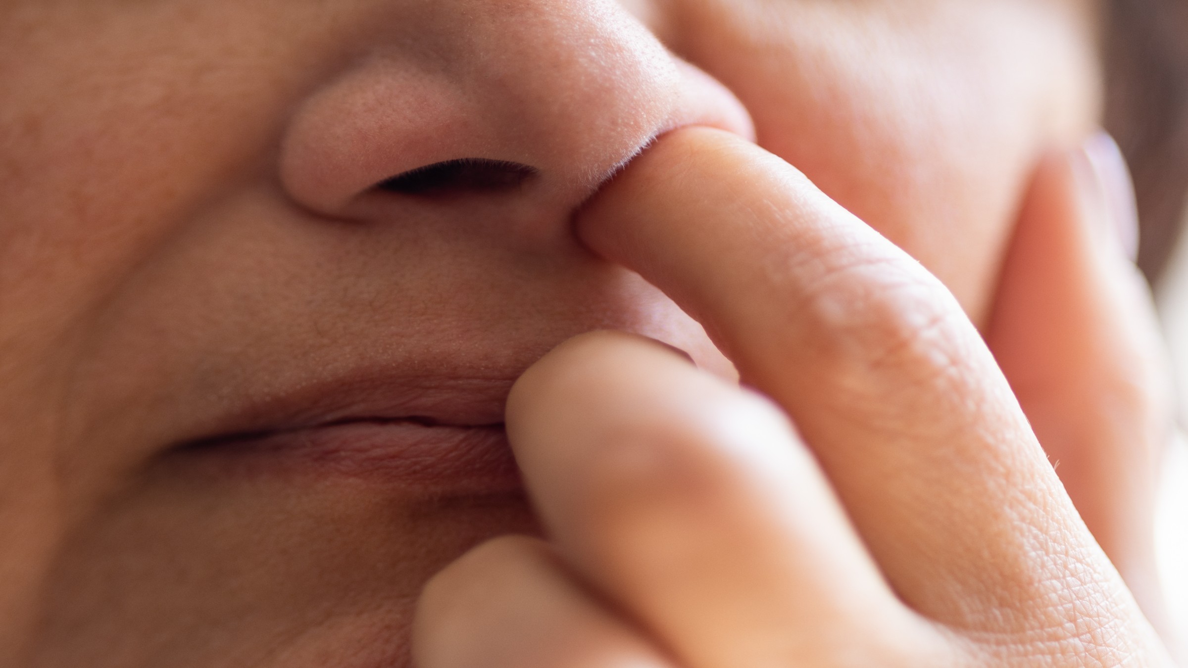 Close up of woman picking her nose